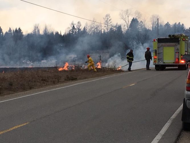 Courtesy photo Escanaba Township firefighters battle a grass fire earlier this month. Spring is a busy time for area firefighters as the risk of wildfires increases dramatically.